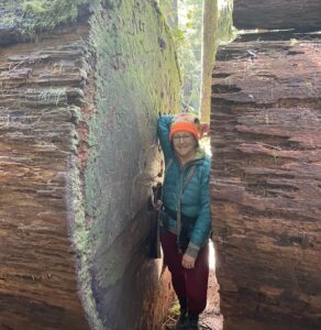 Kyle Isaacs standing next to a very large log