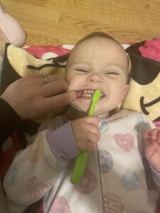 Jozie, 22 months, saying "eeee" while practicing tooth brushing