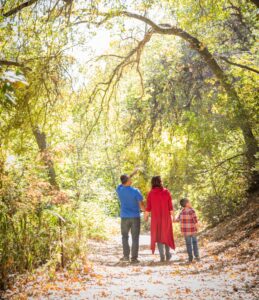 Family walking on a path looking at trees