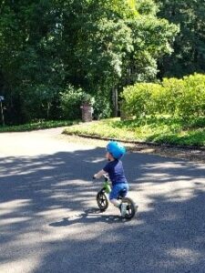 Carson rides his bike in the street