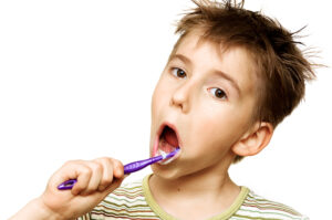 boy brushing teeth, isolated on white