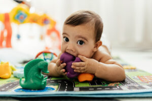 Baby playing with toys on the floor.