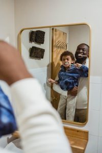 Imagen de padre e hijo cepillándose los dientes juntos