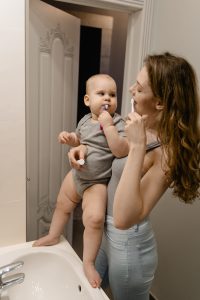 Mamá y bebé se cepillan los dientes juntos en el baño