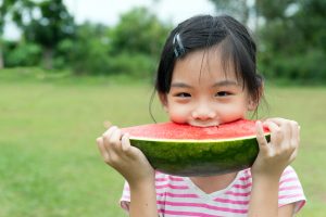 Asian child eating watermelon