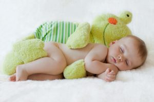 Baby boy, sleeping with a frog toy