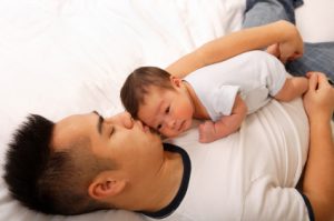 Asian Dad and baby sleeping