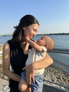 Natalia and Isaiah smiling at each other on a shore line.