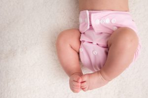 Little baby wearing a pink cloth diaper