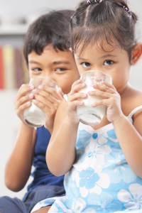 Two small children drinking milk