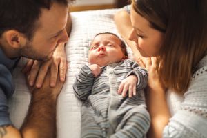 Couple looks down on sleeping newborn