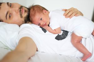 Three weeks old newborn with his father.