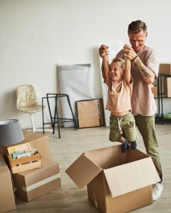 Dad playing with child in moving boxes