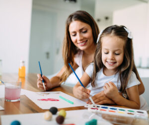 Mom and daughter using water colors at the table