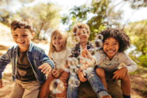 Group of children playing with soap bubbles outdoors. 