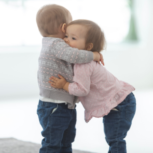 Two toddlers hugging each other
